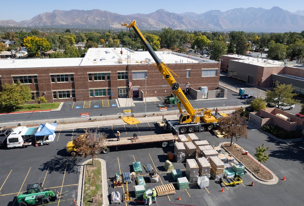 (Francisco Kjolseth | The Salt Lake Tribune) A crew begins the process of installing 510 solar panels to the roof of Whittier Elementary, on Wednesday, Oct. 12, 2022, in order to offset 60% of the school’s energy use.