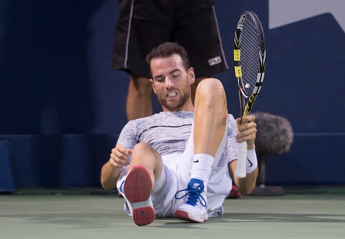 Adrian Mannarino, of France, gets up after sliding during his match against Denis Shapovalov, of Canada, during the quarterfinals at the Rogers Cup tennis tournament Friday, Aug. 11, 2017, in Montreal. (Paul Chiasson/The Canadian Press via AP)