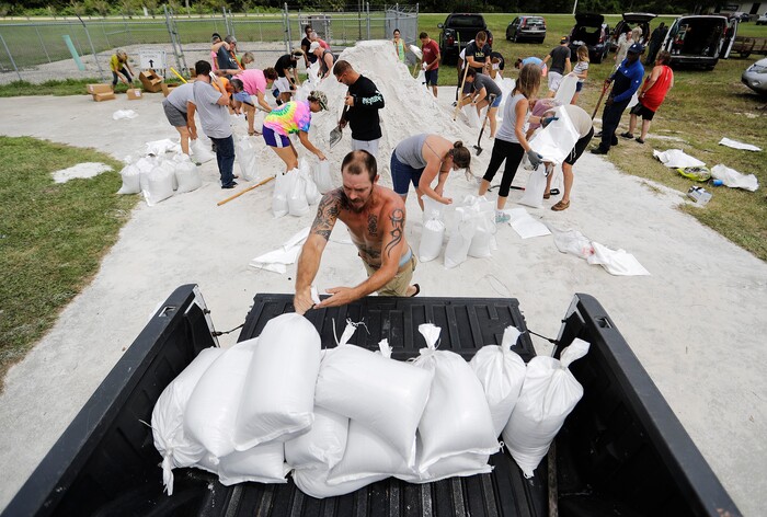 (David Goldman | The Associated Press)  Ryan Kaye loads sandbags into his truck at a makeshift filling station provided by the county as protection ahead of Hurricane Irma, Friday, Sept. 8, 2017, in Palm Coast, Fla.