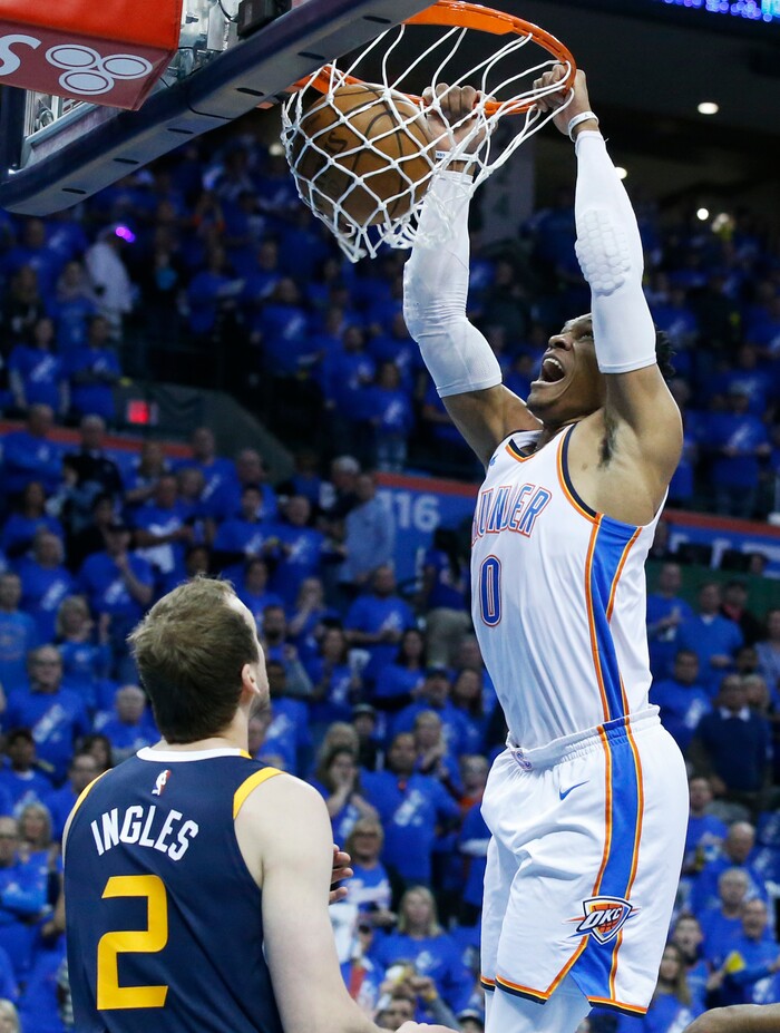Oklahoma City Thunder guard Russell Westbrook, right, dunks in front of Utah Jazz forward Joe Ingles (2) in the first half of Game 1 of an NBA basketball first-round playoff series in Oklahoma City, Sunday, April 15, 2018. (AP Photo/Sue Ogrocki)