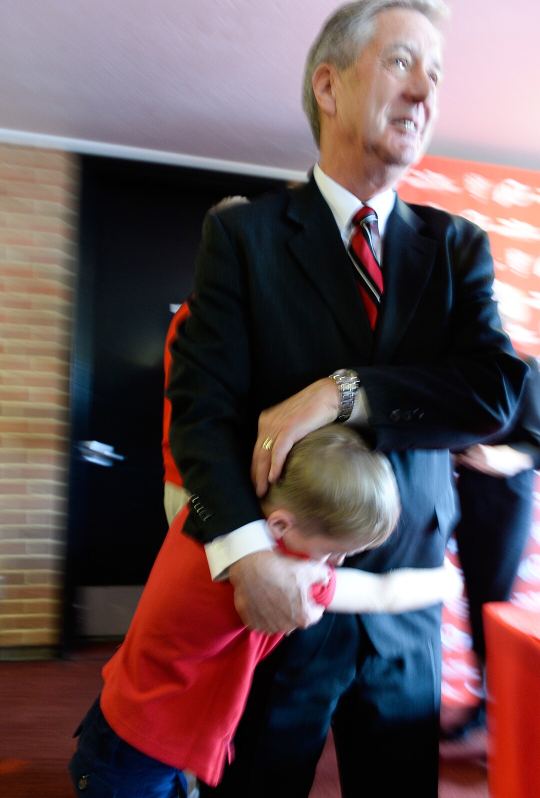 (Francisco Kjolseth  |  The Salt Lake Tribune)  University of Utah Athletics Director Chris Hill is embraced by his grandson Jack Forsyth, 7, after announcing his plan to retire this spring after 31years. 