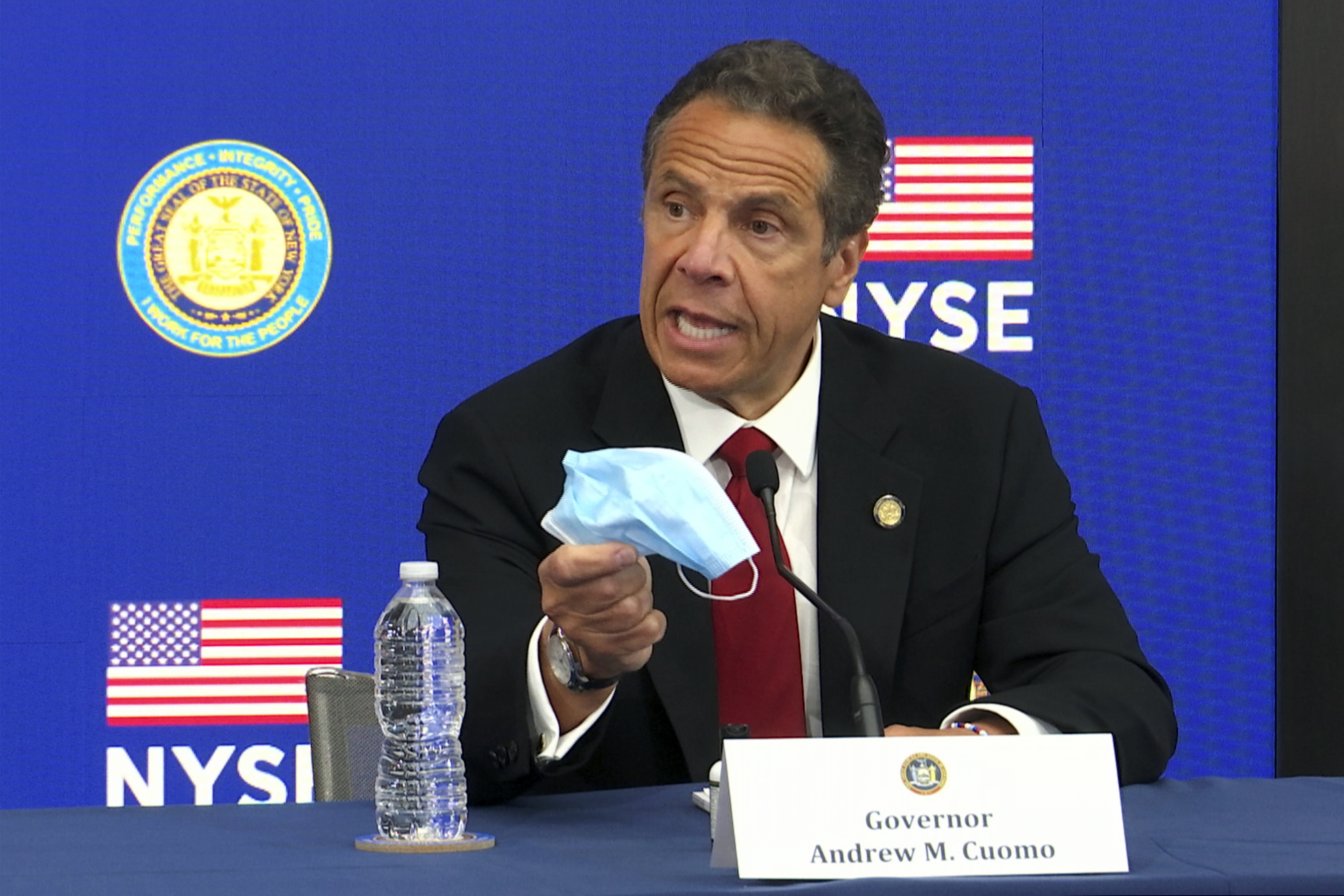 (Ted Shaffrey | AP photo)
New York Gov, Andrew Cuomo holds his face mask while talking to the media at the New York Stock Exchange, Tuesday, March 26, 2020. Gov. Cuomo rang the opening bell as the trading floor partially reopened during the coronavirus pandemic.