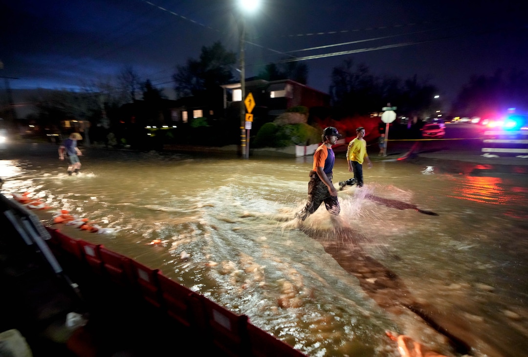 (Francisco Kjolseth | The Salt Lake Tribune) People work to protect homes into the night along 1700 South in Salt Lake City from the rising flow of Emigration Creek through Wasatch Hollow Park on Wednesday, April 12, 2023. 