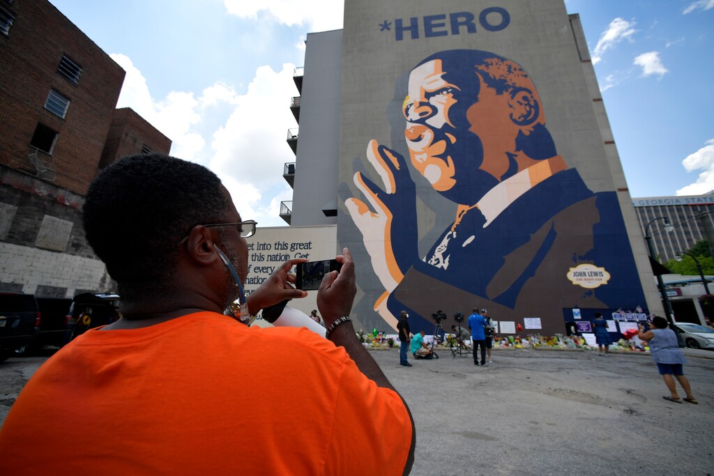 (Mike Stewart | AP file photo) People gather at a memorial near the home of Rep. John Lewis, D-Ga., Sunday, July 19, 2020, in Atlanta.