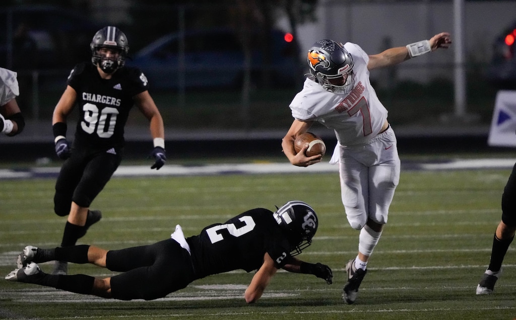 (Francisco Kjolseth | The Salt Lake Tribune) Zach Hale (2) of Corner Canyon tries to take down Skyridge quarterback McCae Hillstead (7) in prep football action between the Corner Canyon Chargers and the Skyridge Falcons, on Friday, Sept. 24, 2021, in Draper.