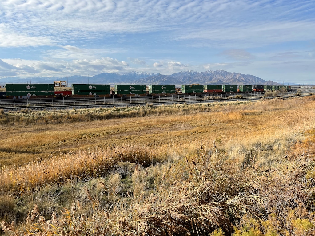 (Francisco Kjolseth | The Salt Lake Tribune) Shipping containers are moved via railcar at the Union Pacific intermodal terminal, west of Salt Lake City on Nov. 10, 2021. Directly south is a large vacant lot the Utah Inland Port Authority is paying millions to lease over a 40-year term, even though it has abandoned plans to build a transloading facility at the site.
