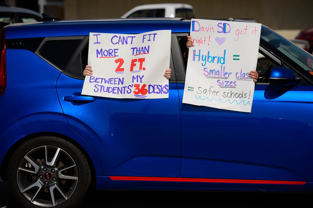 (Trent Nelson  |  Tribune file photo) Signs are held out of a car as teachers and their supporters drive in a caravan to the State Capitol in Salt Lake City in support of school safety in reopening plans, on Friday, Aug. 7, 2020.