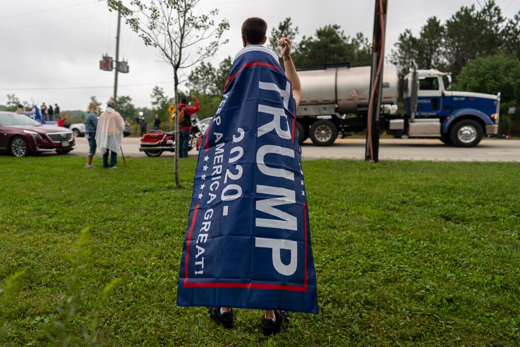 (Carolyn Kaster | AP file photo)  A man with his son atop his shoulders wears a "Trump 2020 Make America Great Again" flag as a cape near the entrance of the Flight 93 National Memorial during a memorial service attended by President Donald Trump in Shanksville, Pa., Friday, Sept. 11, 2020.