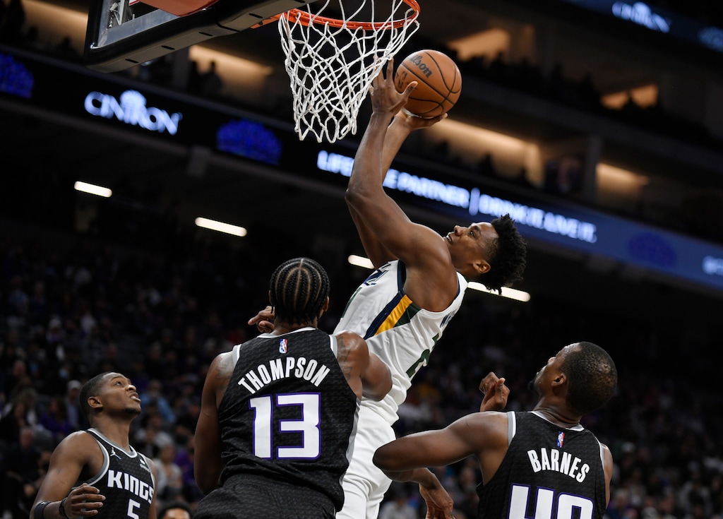 Utah Jazz's Hassan Whiteside scores a basket in front of Sacramento Kings' De'Aaron Fox, left, Triston Thompson and Harrison Barnes during the second half of an NBA basketball game in Sacramento, Calif., Friday, Oct. 22, 2021. The Jazz won 110-101. (AP Photo/José Luis Villegas)