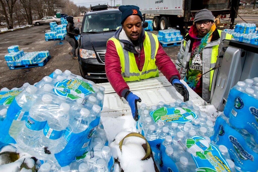 (Bronte Wittpenn /The Flint Journal-MLive.com via AP) Water distribution employee Albrey Kirkland places water cases into the back of a pickup at a water distribution center on North Franklin Avenue on Thursday, April 5, 2018 in Flint, Mich. The state will no longer supply the City of Flint bottled water due to results of Flint's water quality testing below action levels of the federal Lead and Copper Rule. The remaining four water distribution centers will operate until current supply of state-funded bottles run out. Access and functional need deliveries will also close once water supply is out.