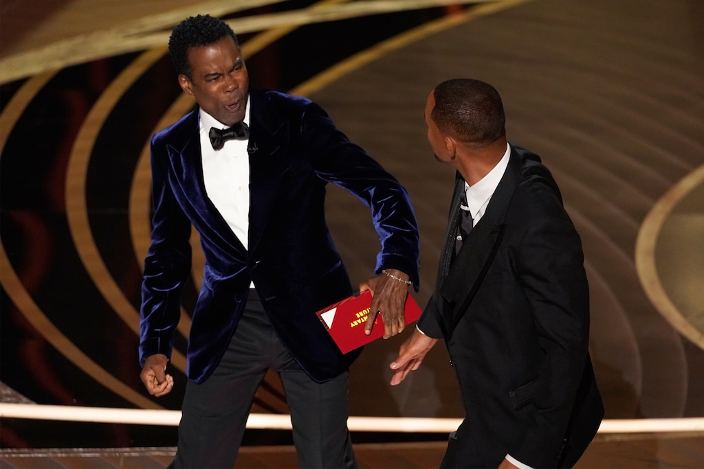 (Chris Pizzello | AP) Presenter Chris Rock, left, reacts after being hit on stage by Will Smith while presenting the award for best documentary feature at the Oscars on Sunday, March 27, 2022, at the Dolby Theatre in Los Angeles.