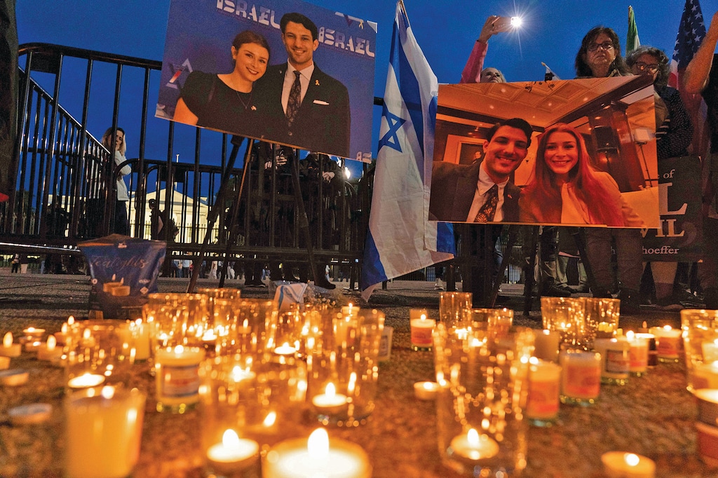 People gather to light candles in a makeshift memorial to honor Yaron Lischinsky and Sarah Milgrim who were killed as they left an event at the Capital Jewish Museum in Washington, during a candlelight vigil outside of the White House in Washington, Thursday, May 22, 2025. (AP Photo/Jose Luis Magana)