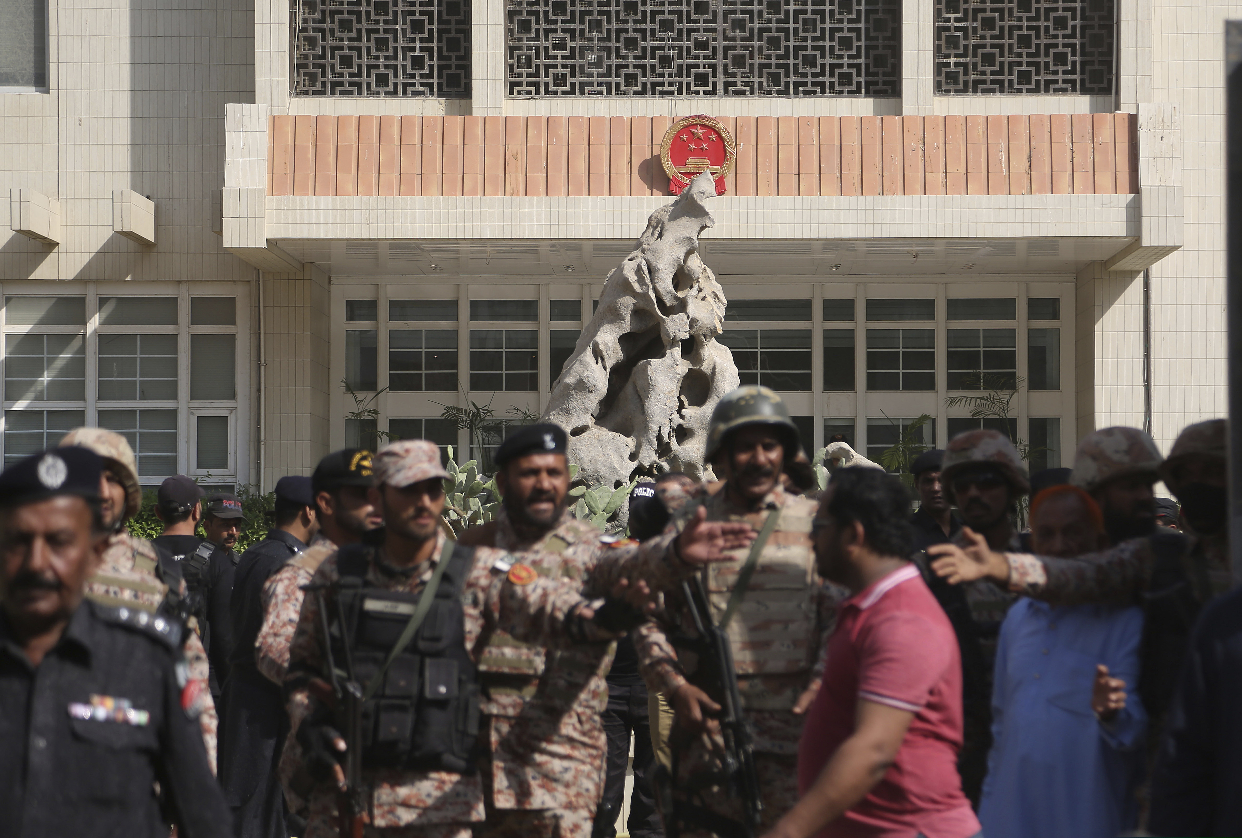 Pakistani troops move in the compound of Chinese Consulate in Karachi, Pakistan, Friday, Nov. 23, 2018. Pakistani police say gunmen have stormed the Chinese Consulate in the country's southern port city of Karachi, triggering an intense shootout. (AP Photo/Shakil Adil)