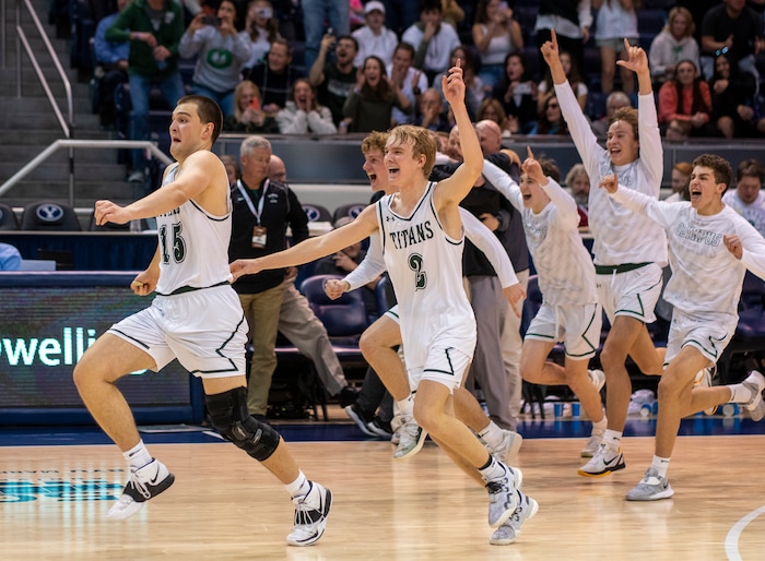 (Rick Egan | The Salt Lake Tribune) 
Olympus Titan, center, Jack Wistrcill (15) and Jordan Barnes (2) celebrate the Titan's win over the Wildcats, in the 5A State Championship game between Woods Cross and Olympus, at the Marriott Center in Provo, on Saturday, March 5, 2022. 