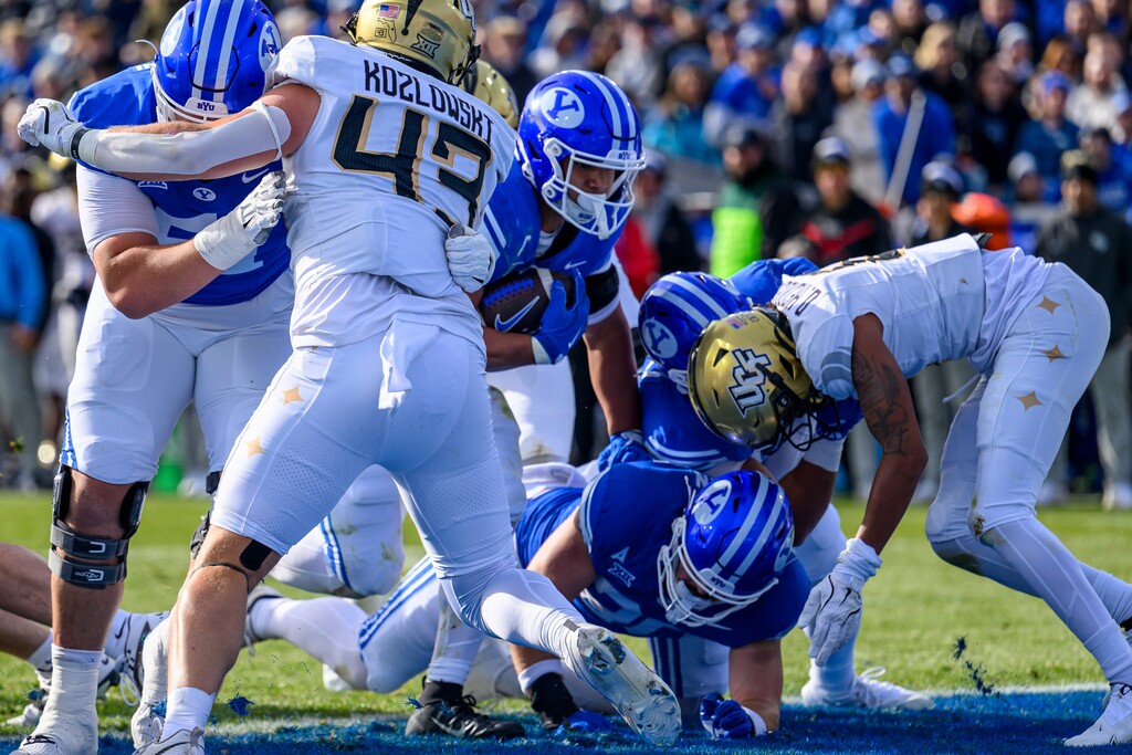 (Tyler Tate | AP) BYU running back LJ Martin, center, runs the ball into the end zone against UCF on Saturday, Nov. 29, 2025, in Provo, Utah.