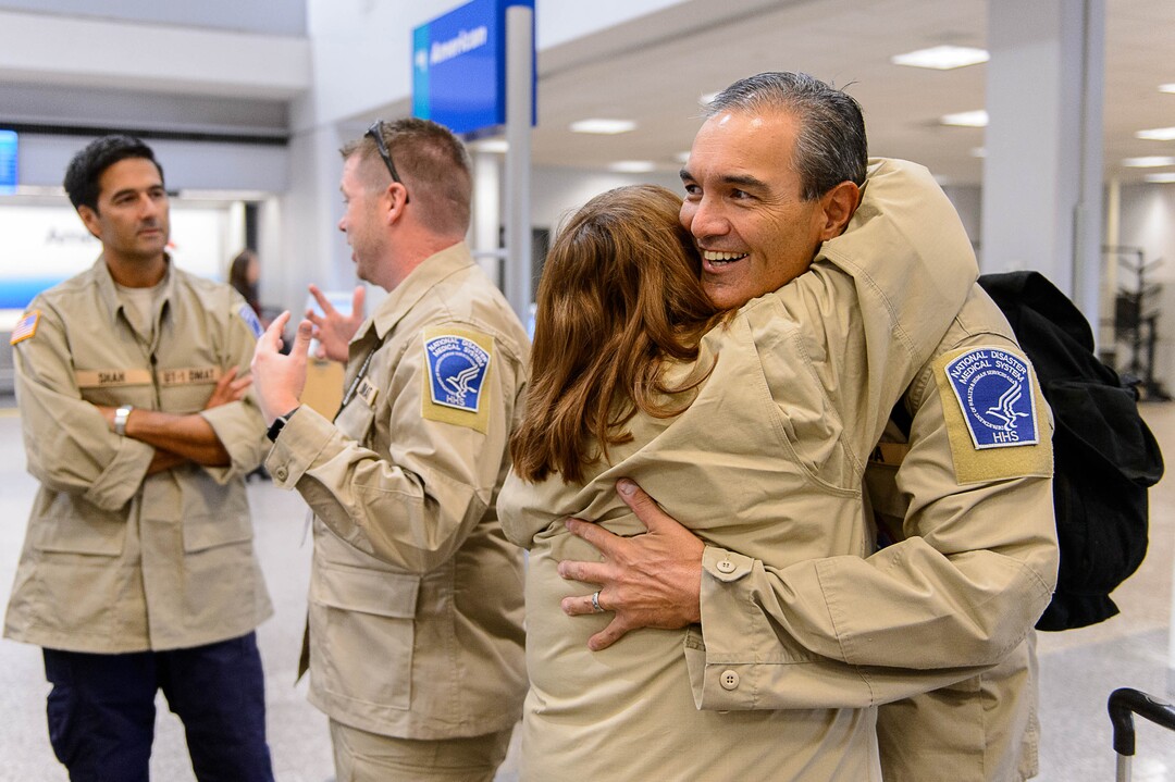 (Trent Nelson | The Salt Lake Tribune)  Chad Pascua and Laura Tramell embrace as members of Utah's DMAT-1 (Disaster Medical Assistance Team) meet at the Salt Lake City Airport en route to Texas, Tuesday August 29, 2017. 36 members of the team are headed to the Houston area to help with the fallout of Hurricane Harvey.