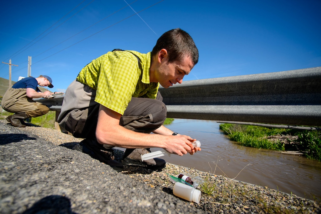 (Trent Nelson  |  The Salt Lake Tribune)  Ben Abbott, Assistant Professor of Ecosystem Ecology at BYU, takes a water sample from the Benjamin Slough on Thursday April 25, 2019.