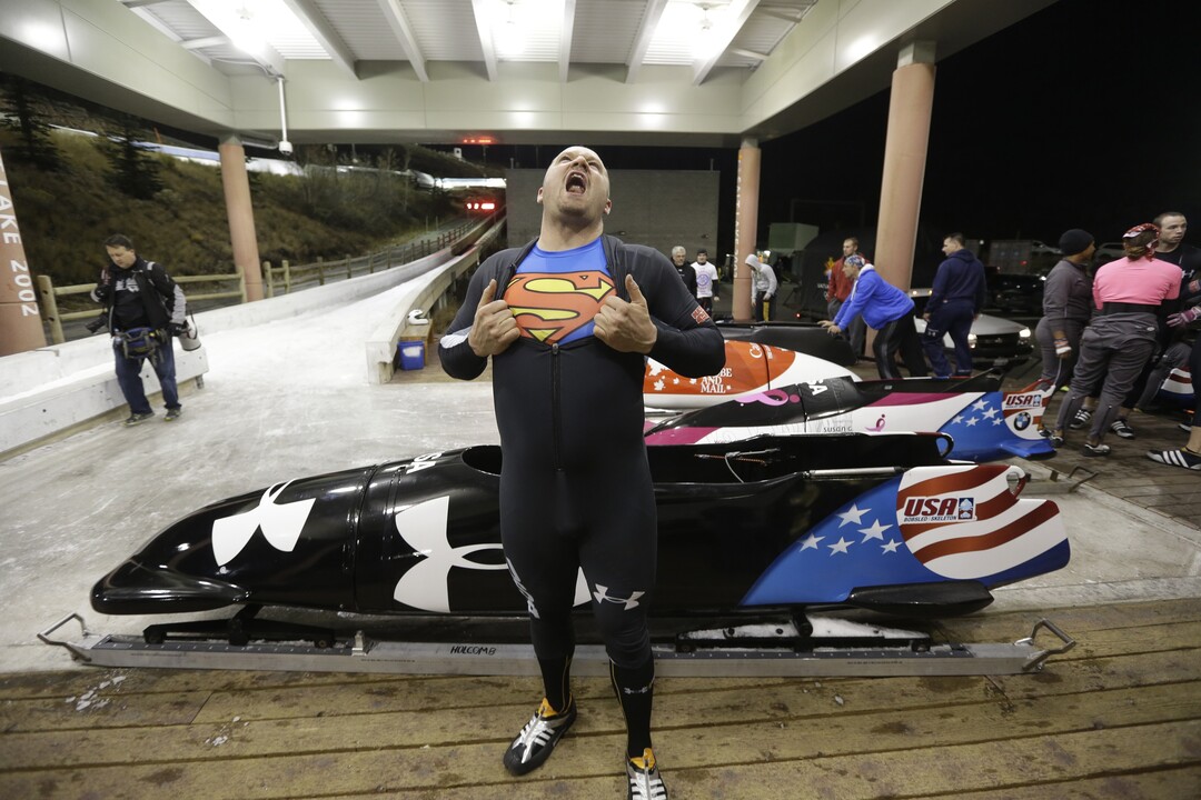 Steve Holcomb displays his Superman shirt as he poses for a photograph in front of his sled after the United States four-man bobsled team trials  on Saturday, Oct. 26, 2013, in Park City, Utah. Holcomb and his crew came in first place. (AP Photo/Rick Bowmer) 