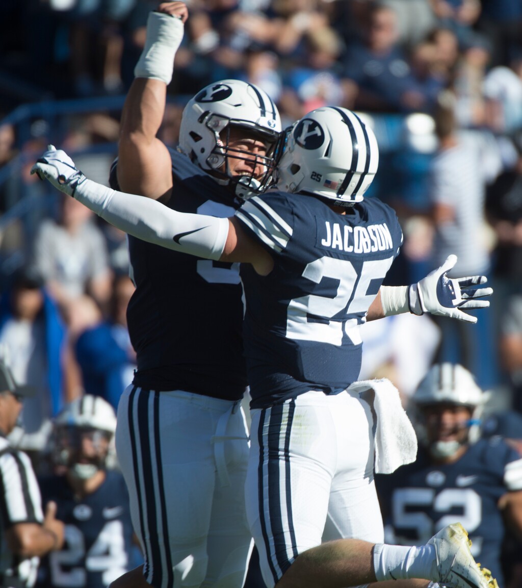 (Rick Egan  |  The Salt Lake Tribune)     Brigham Young defensive lineman Corbin Kaufusi (90) celebrates with linebacker, Tanner Jacobson (25), after Jacobsen intercepted the ball for the Cougars, an interception, in football action between Brigham Young Cougars and McNeese State Cowboys, at Lavell Edwards Stadium, Saturday, Sept. 22, 2018.