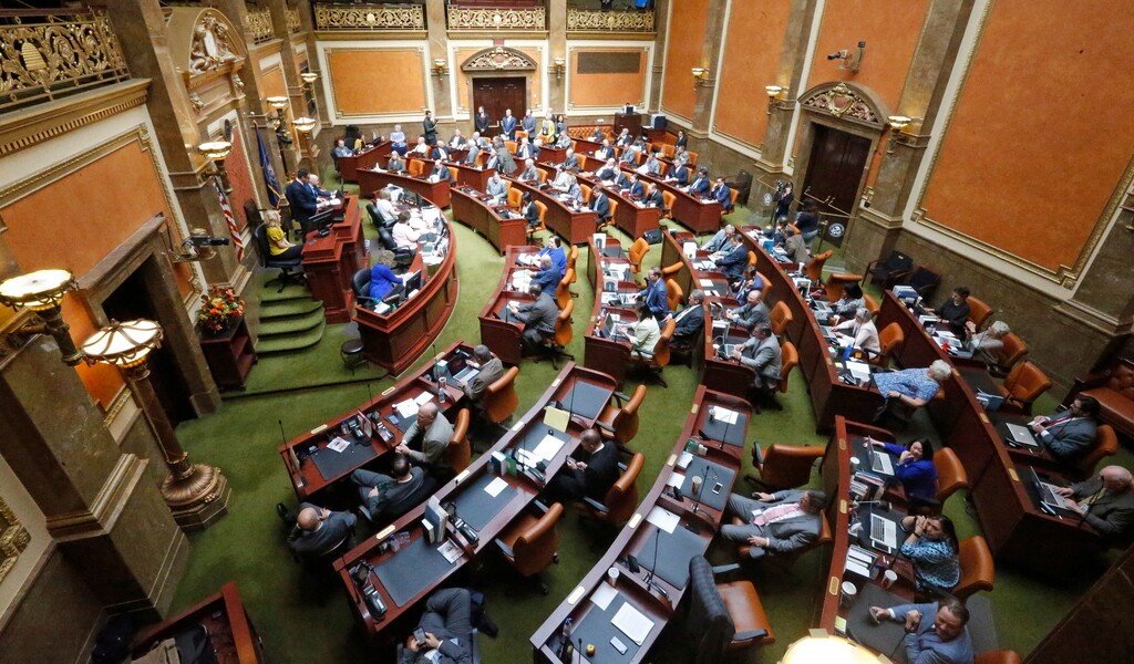 FILE - In this April 18, 2018, file photo, members of the Utah House work on the floor during a special session at the state Capitol in Salt Lake City. Most of the more than 500 laws passed by the state's Legislature this year go into effect Tuesday, May 8, 2018, 60 days after the end of the short legislative session. The laws are wide-ranging. Some add new protections for runaway teens and people with dangerous partners. Another transforms the state’s transit agency, (AP Photo/Rick Bowmer, File)