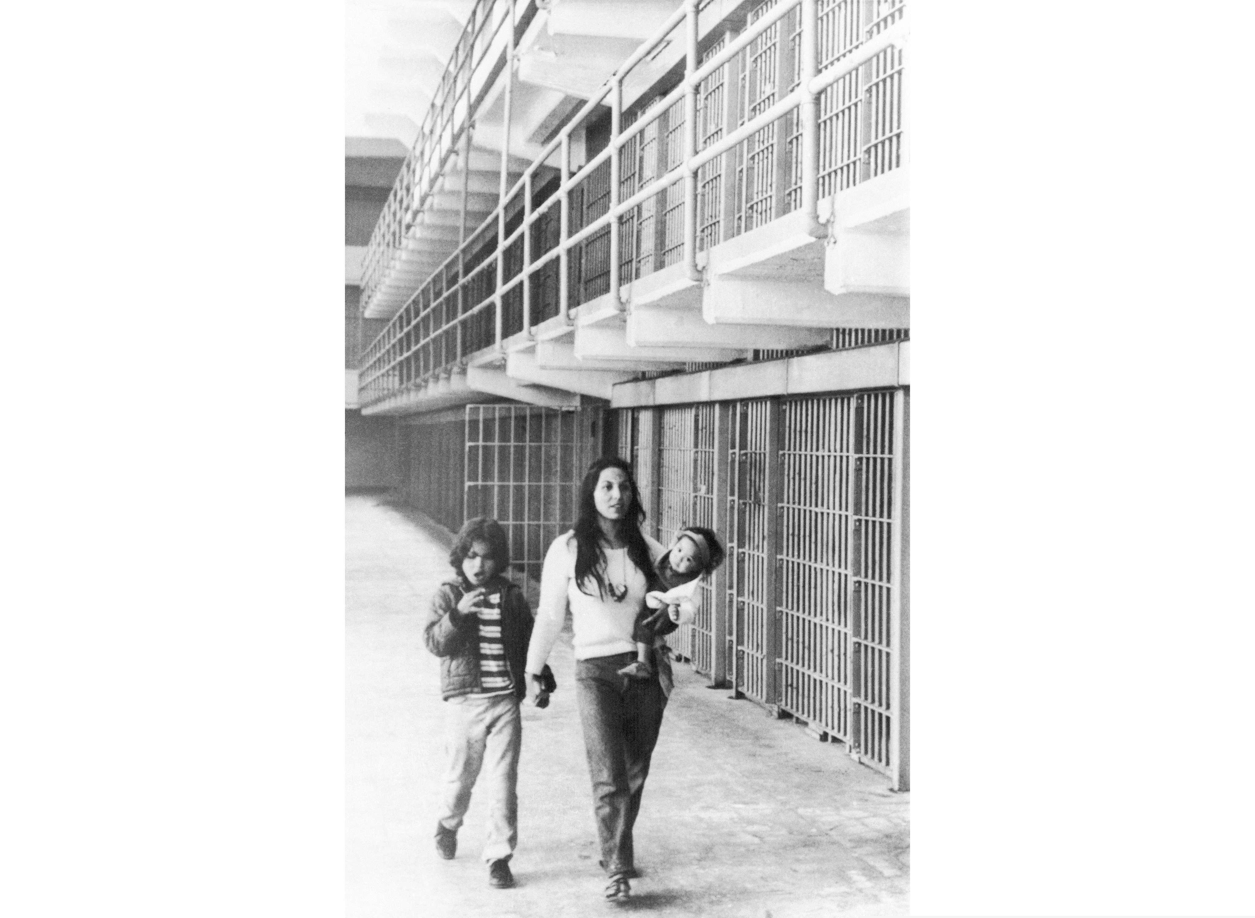 (Richard Drew | AP file photo) In this photo taken March 26, 1970, Eldy Bratt, 33, walks down the lonely corridor of a cell block on Alcatraz with her son Peter Bratt, left, and one of her daughters in San Francisco. The week of Nov. 18, 2019, marks 50 years since the beginning of a months-long Native American occupation at Alcatraz Island in the San Francisco Bay. The demonstration by dozens of tribal members had lasting effects for tribes, raising awareness of life on and off reservations, galvanizing activists and spurring a shift in federal policy toward self-determination.