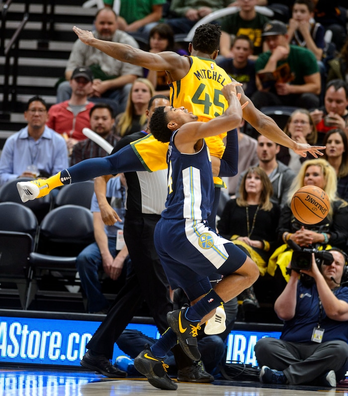 (Steve Griffin  |  The Salt Lake Tribune) Utah Jazz guard Donovan Mitchell (45) lands on the shoulders of Denver Nuggets guard Gary Harris (14) during the Utah Jazz versus Denver Nuggets NBA basketball game at Vivint Smart Home Arena  in Salt Lake City Tuesday November 28, 2017.
