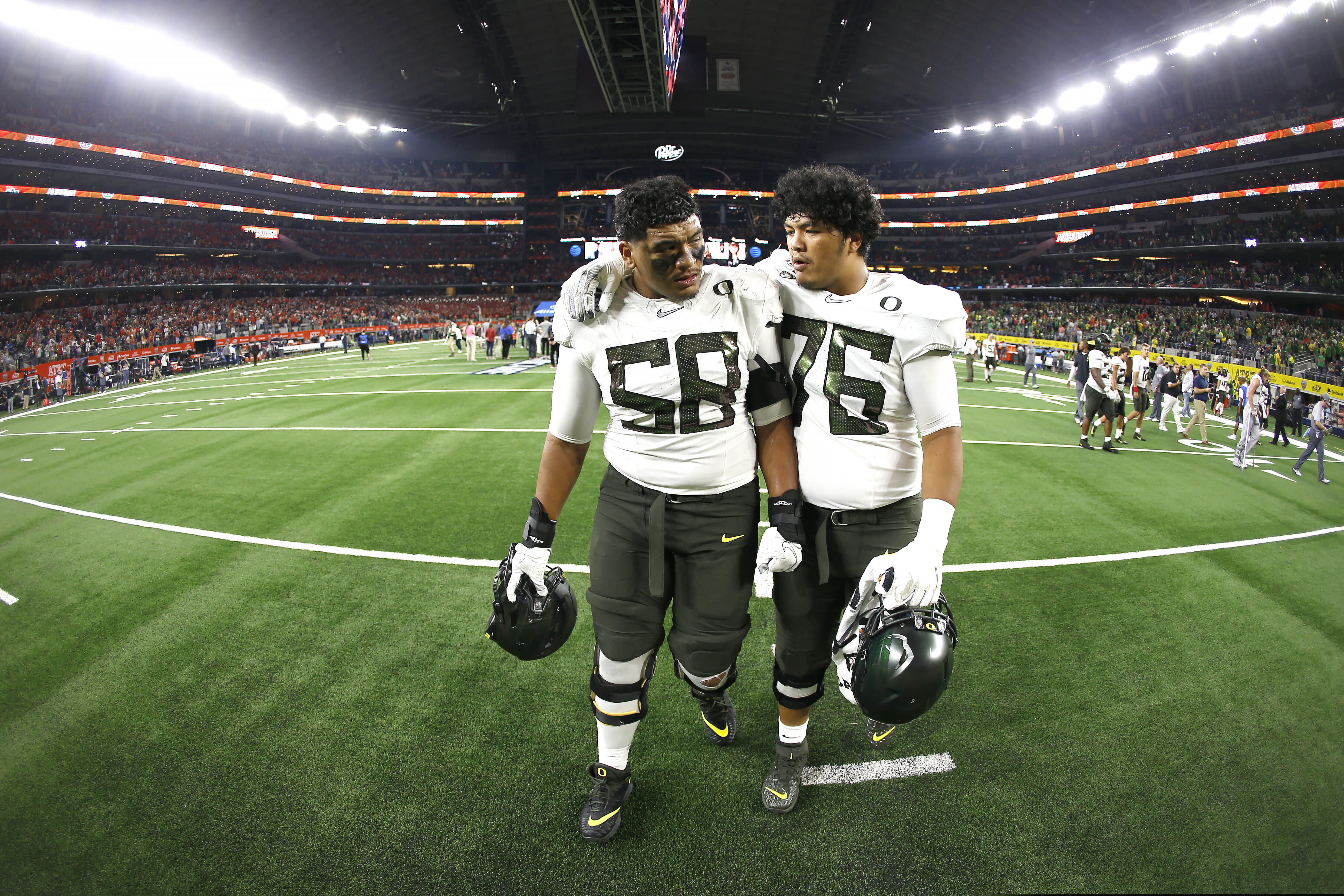 (Ron Jenkins | AP file photo) Oregon offensive linemen Penei Sewell (58) and Jonah Tauanu'u (76) walk off the field after the team's 27-21 loss to Auburn in August.