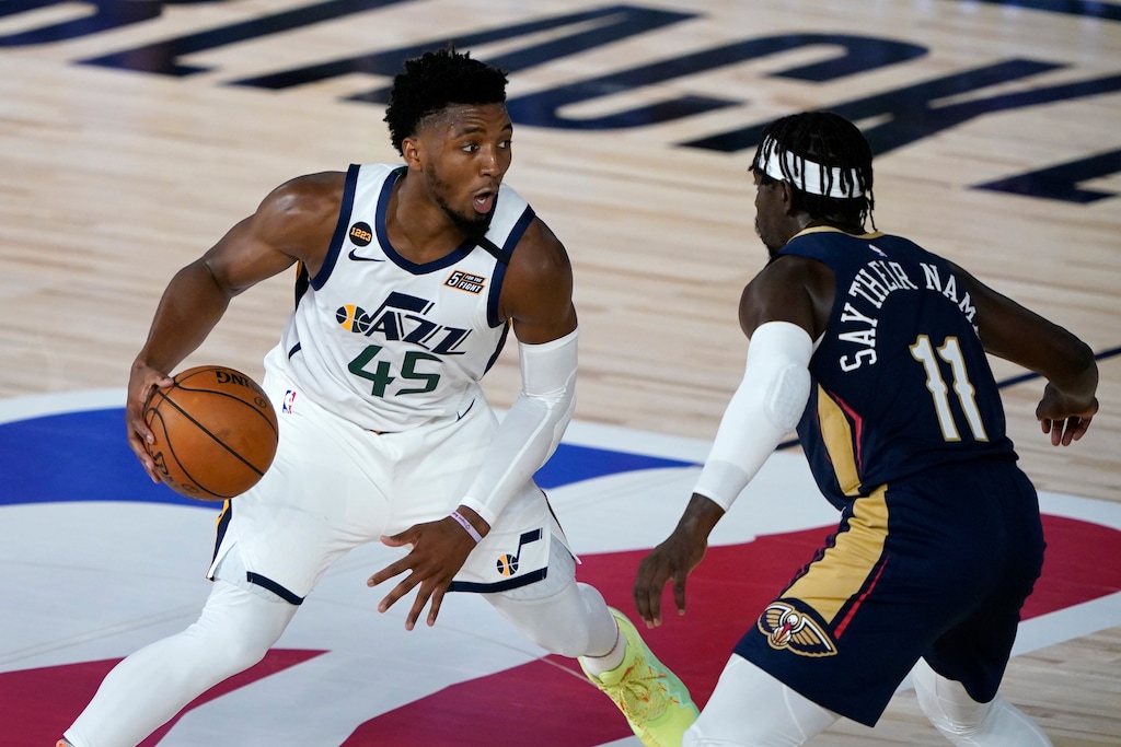 Utah Jazz's Donovan Mitchell (45) heads to the basket past New Orleans Pelicans' Jrue Holiday (11) during the second half of an NBA basketball game Thursday, July 30, 2020, in Lake Buena Vista, Fla. (AP Photo/Ashley Landis, Pool)