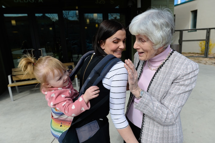 (Francisco Kjolseth | The Salt Lake Tribune) Eva May Densley, 1, carried by her mother Michelle, calls out "grandma" after catching a glimpse of champion for the homeless Pamela Atkinson while touring the YWCA Center for Women & Familes in Salt Lake on Tuesday, March 20, 2018. Michelle, a mother of three who lived out of her car and peoples homes for a time feels blessed to have landed an apartment at the women's center after experiencing violent abuse from her former husband during her pregnancy with Eva. Atkinson is encouraging people to donate to the Pamela Atkinson Homeless Trust Fund through their tax forms.