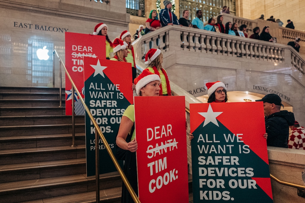 (Jeenah Moon | The New York Times) Child safety advocates demonstrate at the Apple Store in New York’s Grand Central Terminal on Nov. 5, 2024. Smartphone apps downloaded from Apple and Google can allow parents and other abusers to connect with pedophiles who pay to watch — and direct — criminal behavior.