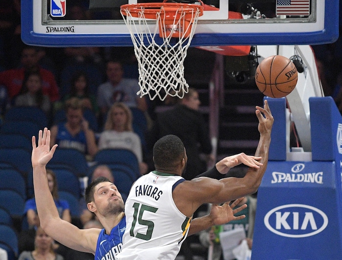 Utah Jazz forward Derrick Favors (15) is fouled by Orlando Magic center Nikola Vucevic, while going up for a shot, during the first half of an NBA basketball game, Saturday, Nov. 18, 2017, in Orlando, Fla. (AP Photo/Phelan M. Ebenhack)
