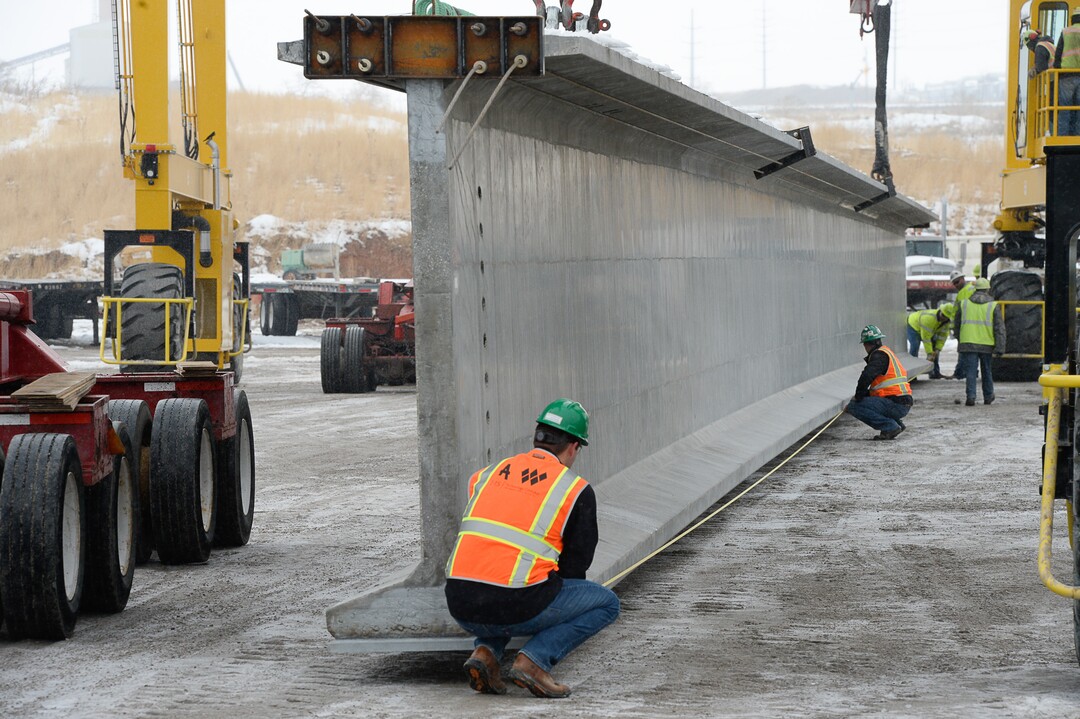 (Francisco Kjolseth  |  The Salt Lake Tribune)  UDOT gets ready to place some of the world's largest-ever bridge beams, and the largest in Utah state history with a span of 203 ft long and just over 8 ft tall, as crews load one on a truck following manufacturing at Forterra Structural Precast in Kearns on Tuesday, Dec. 11, 2018. A total of six beams will be installed in the technology corridor in Lehi later this week.