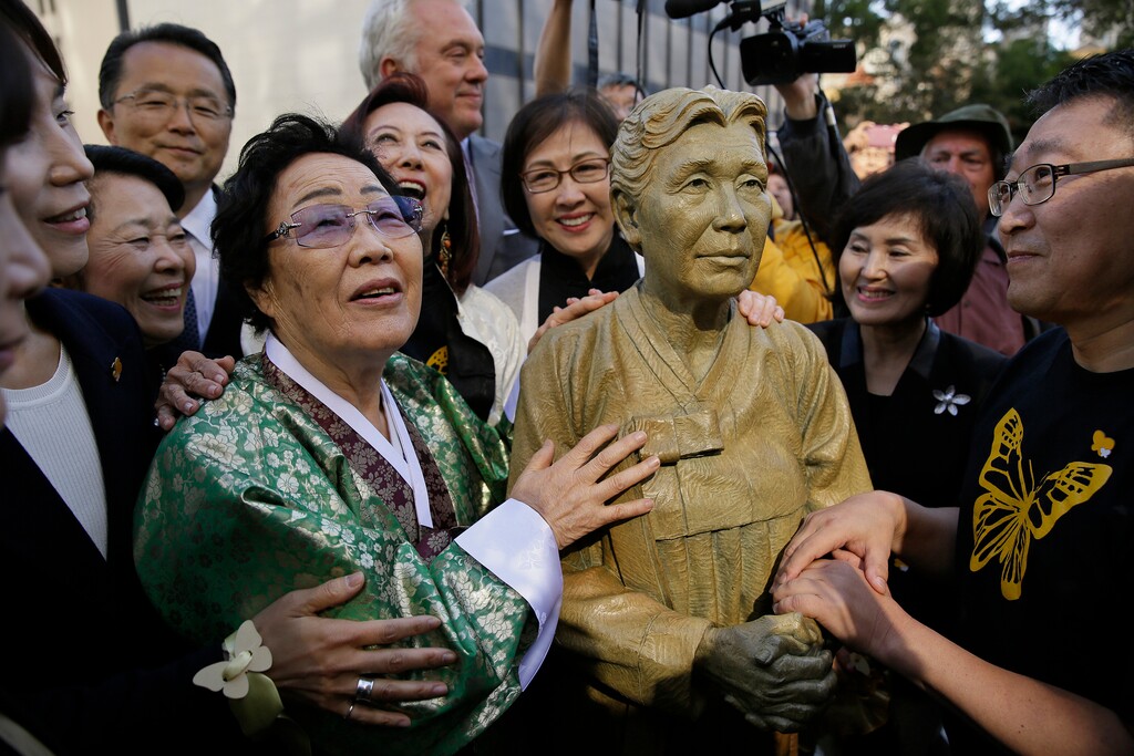 (Eric Risberg | The Associated Press) In this Friday, Sept. 22, 2017, file photo, former World War II "comfort woman" Yongsoo Lee, 89, of South Korea, stands by a statue of Haksoon Kim while looking at the "Comfort Women" monument after it was unveiled in San Francisco. Japan has expressed strong regret over San Francisco's decision to give formal city property status to a statue commemorating women who worked in military-backed brothels for Japanese troops during World War II, with Osaka declaring it will terminate its 60-year sister-city ties.