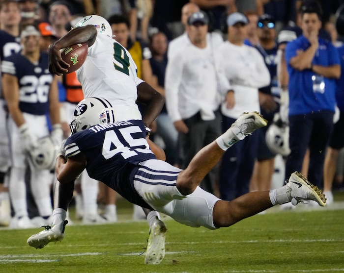 (Francisco Kjolseth | The Salt Lake Tribune) South Florida Bulls quarterback Timmy McClain (9) tries to outrun DUPLICATE***Brigham Young Cougars defensive lineman Pepe Tanuvasa (45) in game action between the Brigham Young Cougars and the South Florida Bulls at LaVell Edwards Stadium in Provo, Saturday, Sept. 25, 2021.