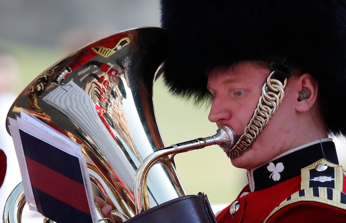 A military brass band player plays a tuba prior to the wedding ceremony of Prince Harry and Meghan Markle at St. George's Chapel in Windsor Castle in Windsor, near London, England, Saturday, May 19, 2018. (AP Photo/Frank Augstein)