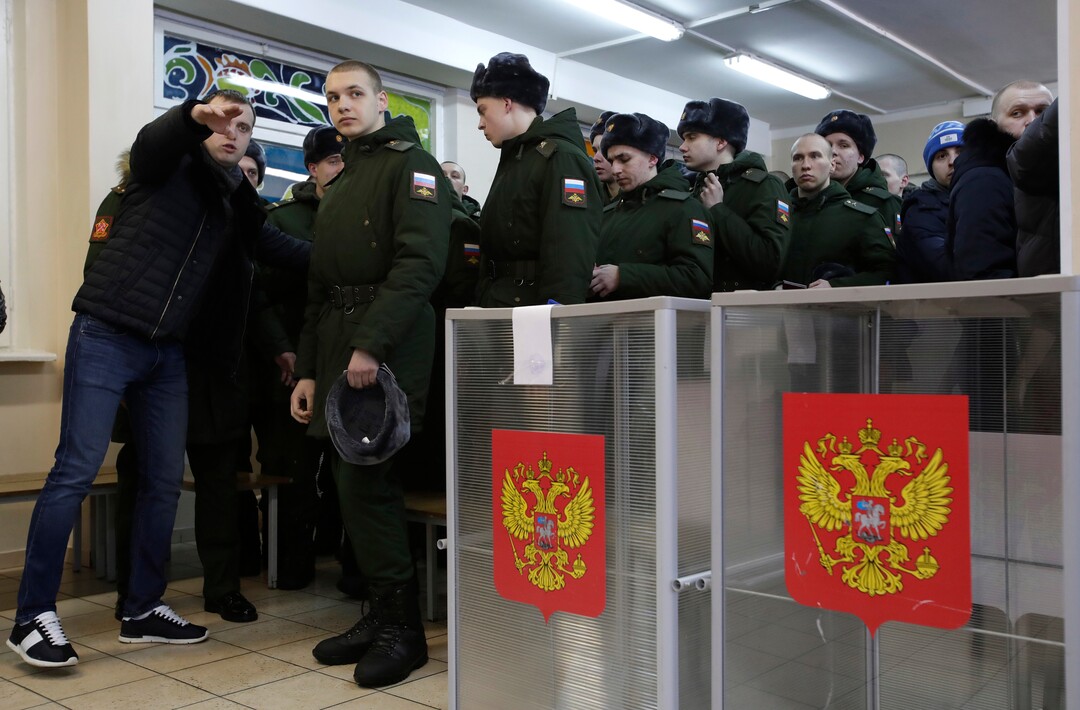 Russian servicemen line-up to vote in the Russian presidential election in St. Petersburg, Russia, Sunday, March 18, 2018. Russians are voting in a presidential election in which Vladimir Putin is seeking a fourth term in the Kremlin. (AP Photo/Dmitri Lovetsky)