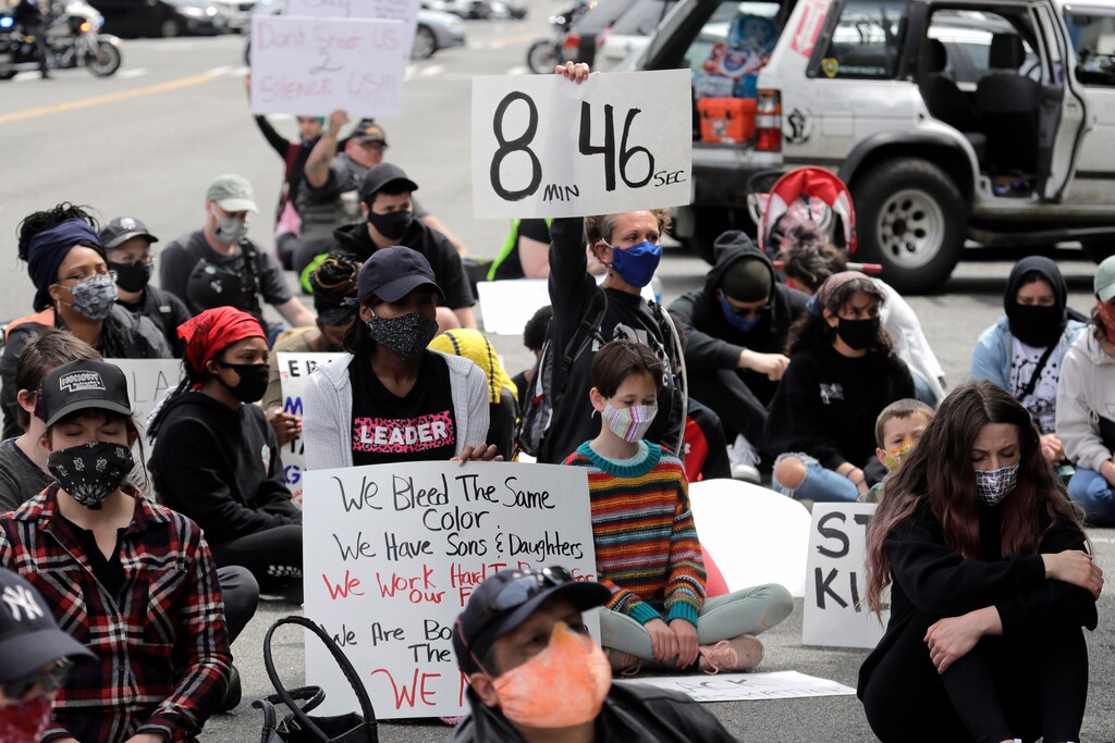 (Ted S. Warren | AP file photo) A protester holds a sign that reads "8:46" Friday, June 5, 2020, in Tacoma, Wash., during a protest against police brutality and the death of George Floyd, a black man who died after being restrained by Minneapolis police officers on May 25. Protesters sat or lay on the ground for 8 minutes, 46 seconds, Friday, the amount of time Floyd was held down by police.