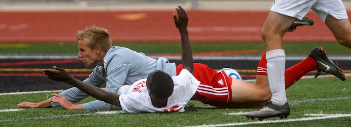 (Steve Griffin  |  The Salt Lake Tribune) Delta's Jager Springer falls on Judge's Emmanuel Okongo during the Class 3A boys' soccer state semifinal at Alta High School in Sandy Friday May 11, 2018.
