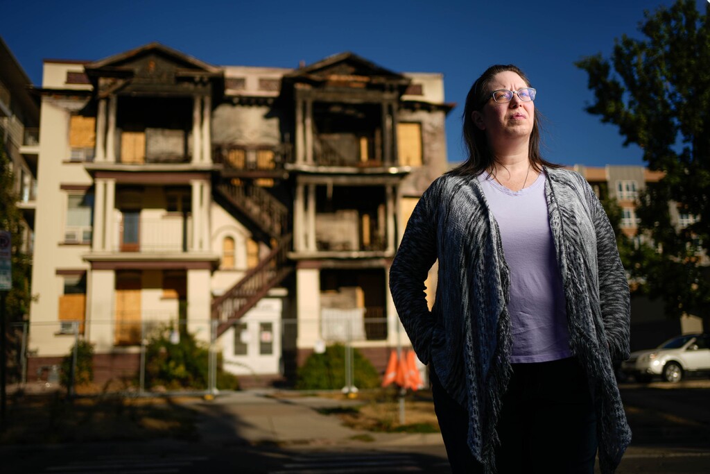 (Francisco Kjolseth | The Salt Lake Tribune) Erica Larabee is pictured on Monday, Sept. 26, 2022, in front of the Silverado Apartments in Salt Lake City where she had been a 15-year resident before it burned on May 30, 2022. For former tenants, the brick building is a constant reminder of the fatal fire called a “preventable tragedy.”