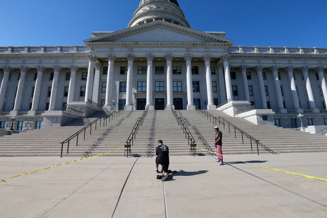 Shane Brooks, a Marine Corps veteran, kneels for nine hours outside the Utah Capitol to call attention to racial injustice, police brutality and mental health, Thursday, Aug. 6, 2020, in Salt Lake City. Brooks said people of color with mental illness are "looked at as if they have already committed a crime" and some end up dead in encounters with police, KTVX-TV reported. Brooks said his marathon silent protest was inspired by Bobby Duckworth, a 26-year-old who was shot and killed in 2019 by police responding to a report of a suicidal person in Wellington, Utah. (AP Photo/Rick Bowmer)