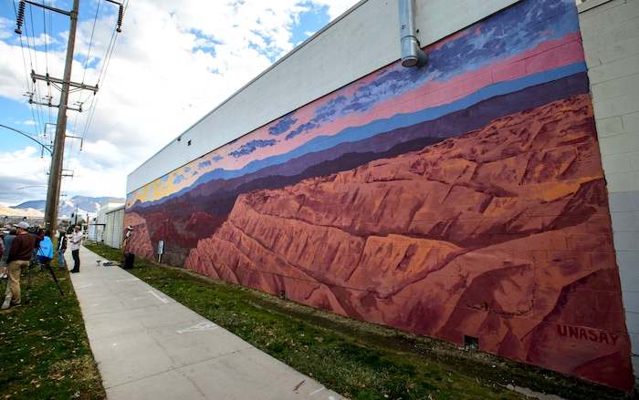 (Steve Griffin  |  The Salt Lake Tribune) Utah graphic artist Josh Scheuerman stands in front of his mural of landscapes from Bears Ears National Monument during a dedication ceremony on 800 South near 300 West in Salt Lake City on Friday, Nov. 24, 2017.