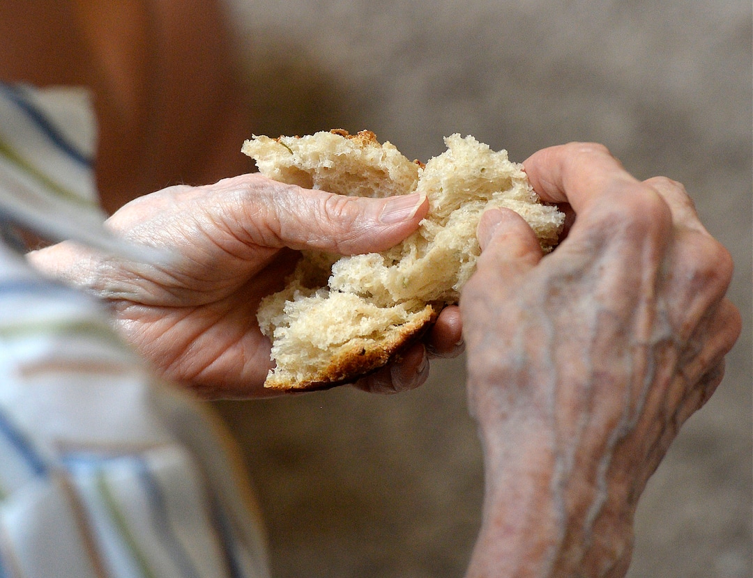 (Al Hartmann  |  The Salt Lake Tribune)
A Remnant follower breaks large crust of broken bread served as sacrament during a Sandy meeting.