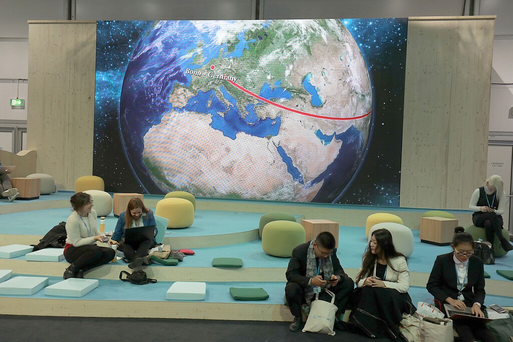 Participants at the World Climate Conference working in front of the depiction of a globe in Bonn, Germany, Tuesday, Nov. 7, 2017. (Oliver Berg/dpa via AP)