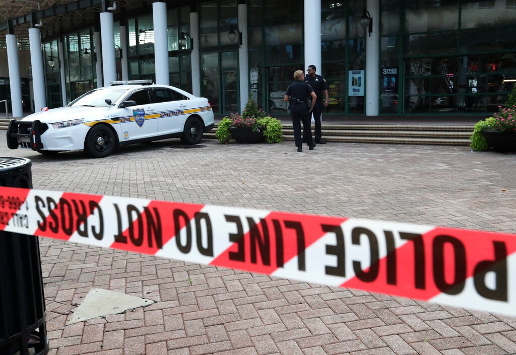 (AP Photo/John Raoux) Jacksonville police officers guard an area Monday, Aug. 27, 2018, near the scene of a fatal shooting at The Jacksonville Landing on Sunday in Jacksonville, Fla. A gunman opened fire at a video game tournament killing multiple people and then fatally shooting himself in a rampage that wounded several others.