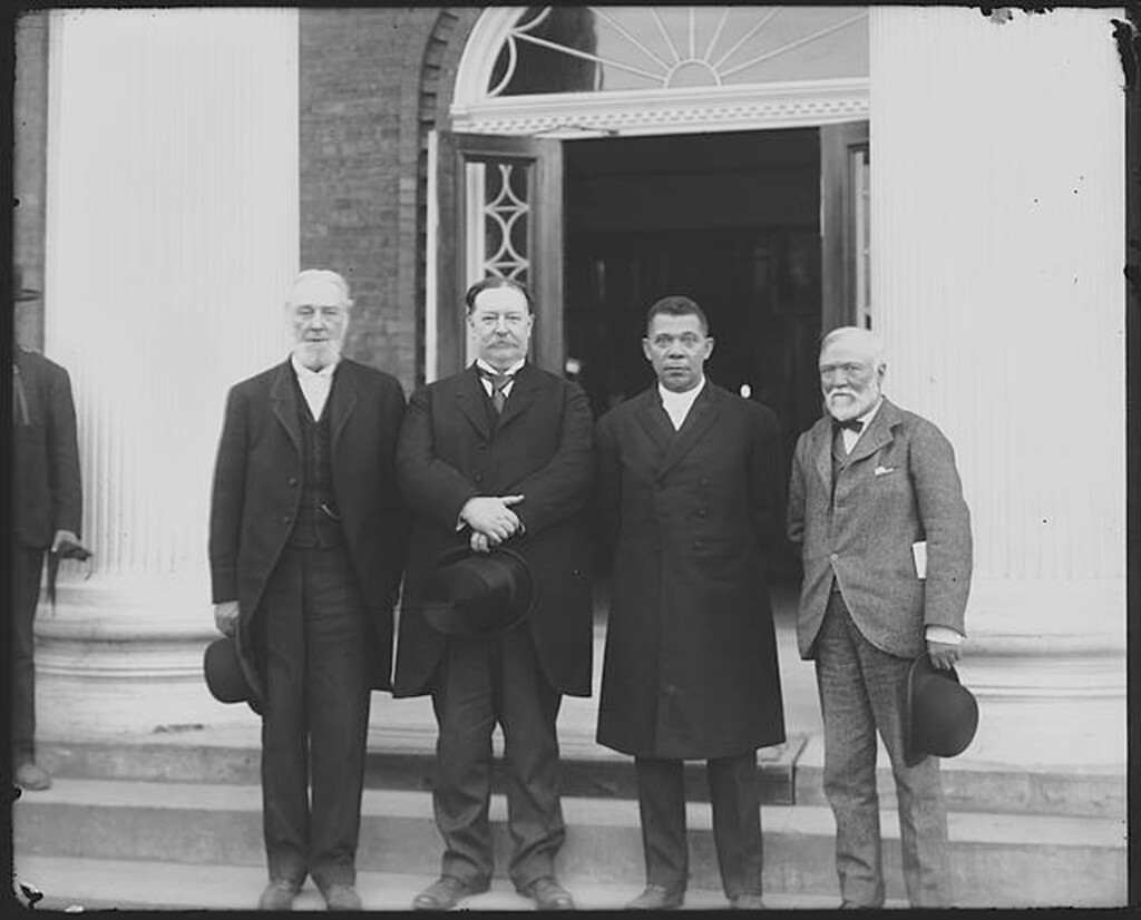 Robert C. Ogden, William Howard Taft, Booker T. Washington and Andrew Carnegie, left to right, stand on the steps of a building in April 1906 during the 25h anniversary celebration of what is now Tuskegee University in Tuskegee, Ala. Taft would later become president. The event was held at the same time a Southern heritage group, the United Daughters of the Confederacy, was raising money to erect a Confederate monument that was dedicated in 1909 and still stands at the center of the mostly black city. (Frances Benjamin Johnston/Library of Congress via AP)