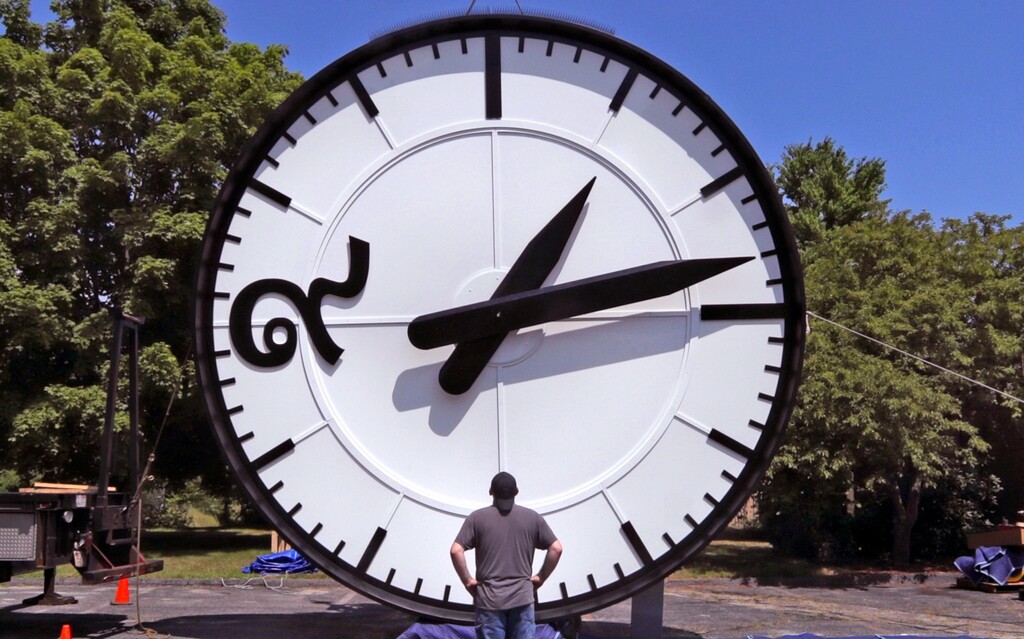 (Charles Krupa | AP file photo) Workers at the Electric Time Company in Medfield, Mass., test a 20-foot-high clock, built for the a new train station in Bangkok, Thailand, prior to packing and shipment on July 25, 2019. Daylight saving time ends at 2 a.m. local time Sunday, Nov. 3, 2019, when clocks are set back one hour. Losing an hour of daylight sounds like a gloomy preview for the dark winter months, and at least one study found an increase in people seeking help for depression after turning the clocks back to standard time in November _ in Scandinavia. But far more research says that the springtime start of daylight saving time may be more harmful, linking it with more car accidents, heart attacks in vulnerable people and other health problems that may persist throughout the time change.