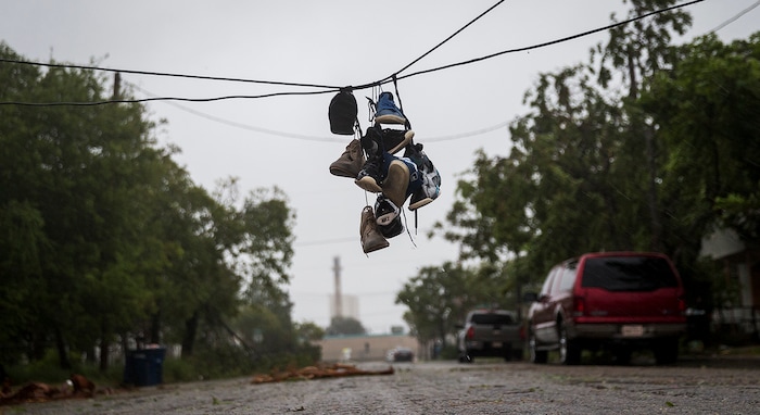 (Nick Wagner | Austin American-Statesman via AP) Shoes tied to a power line hang near a street after winds from Hurricane Harvey brought down a power pole in Corpus Christi, Texas, on Friday, Aug. 25, 2017. Hurricane Harvey smashed into Texas late Friday, lashing a wide swath of the Gulf Coast with strong winds and torrential rain from the fiercest hurricane to hit the U.S. in more than a decade.