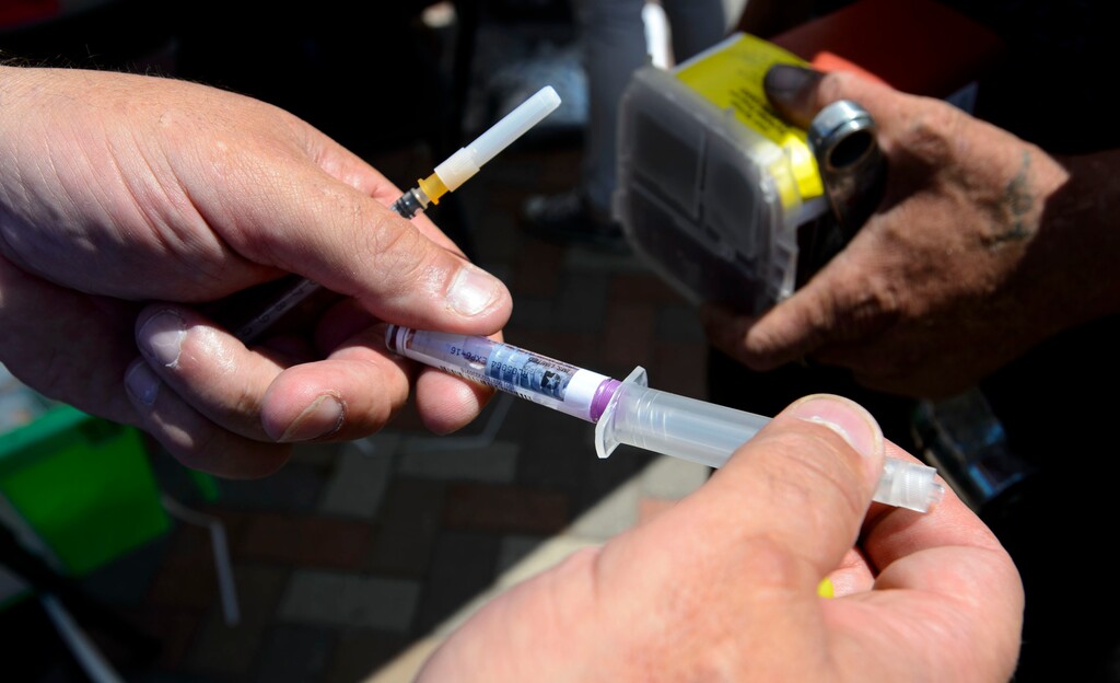 Steve Griffin  |  The Salt Lake Tribune


Volunteer Damon Harris shows users how to use naloxone, a medication approved by the Food and Drug Administration (FDA) to prevent overdose by opioids such as heroin, as he helps members of the Utah Harm Reduction Coalition as they exchange needles on 500 west between 200 south and 300 south in Salt Lake City, Thursday July 27, 2017. Users are able to exchange used needles and also receive naloxone during the exchange. The state's increased attention to the Rio Grande neighborhood comes as Utah's leading needle-exchange provider is under fire for handing out more needles than it collects. Mindy Vincent, founder of the coalition, says the goal was never to break even, and that optics aside, needle exchange is proven to reduce the spread of disease among IV drug users.