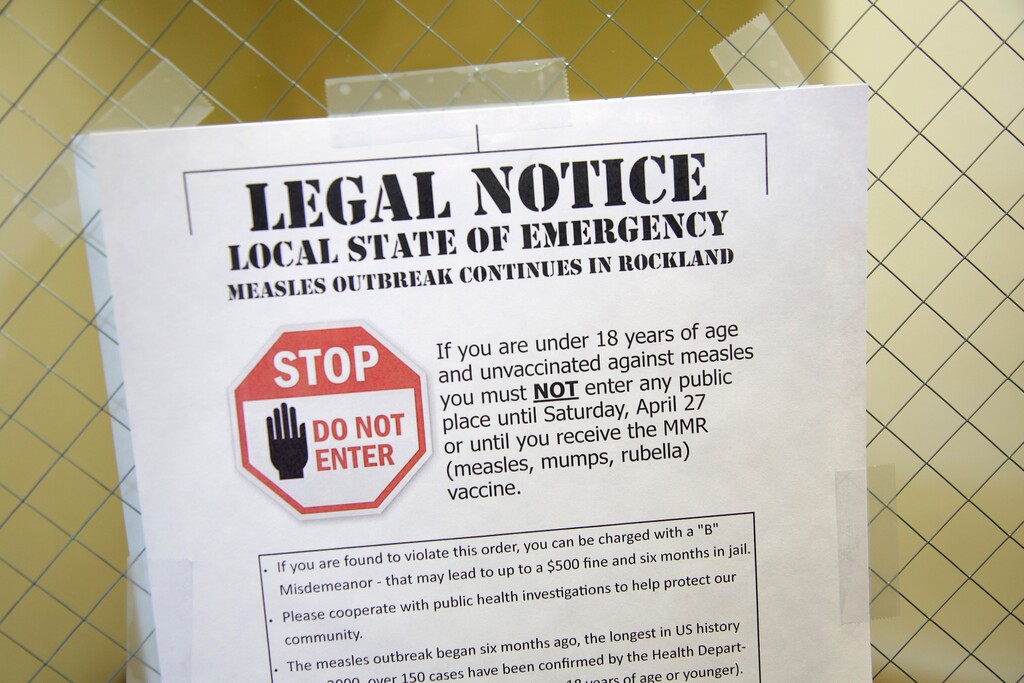 A sign explaining the local state of emergency is displayed at the Rockland County Health Department in Pomona, N.Y., Wednesday, March 27, 2019. The county in New York City's northern suburbs declared a state of emergency Tuesday over a measles outbreak that has infected more than 150 people since last fall, hoping a ban against unvaccinated children in public places wakes their parents to the seriousness of the problem. (AP Photo/Seth Wenig)