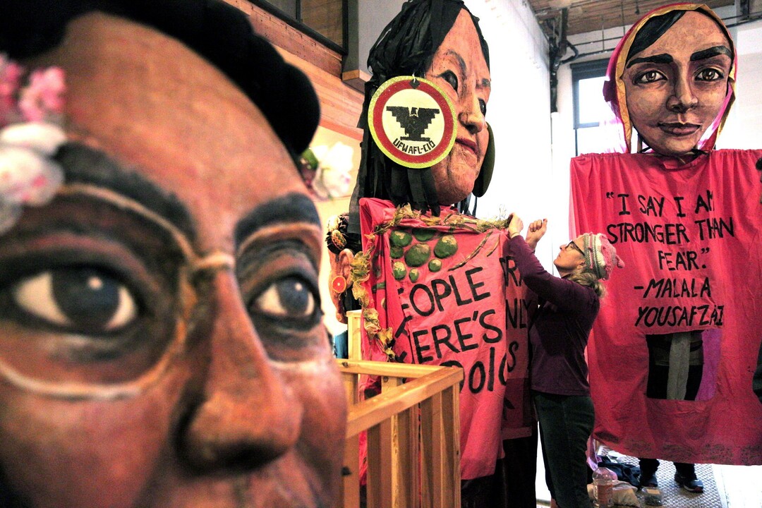 Norma Baum helps Michael O'Hara get situated in the Dolores Huerta puppet before the Women's March 2.0, in Seattle on Saturday, Jan. 20, 2018. Baum, who made the puppets for the march last year with 30 volunteers, said, "It means everything. The energy is so incredible that people are coming to these events. They inspired me." (Courtney Pedroza/The Seattle Times via AP)
